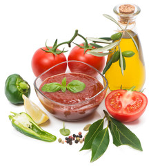 Bowl of tomato sauce with fresh ingredients on white