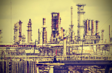Old industrial plant with gray sky, vintage retro style.