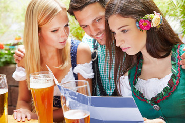 Freunde schauen in Speisekarte im Biergarten