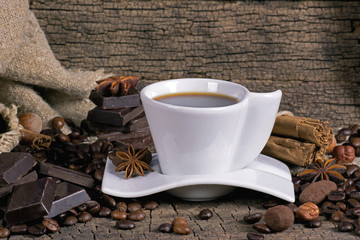 Cup of coffee with coffee beans, chocolate and spices
