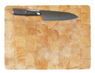 Kitchen knife laying on used chopping board