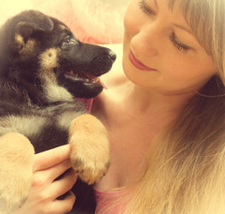 young woman holding a German Shepherd puppy