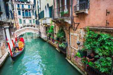 Naklejka premium Tourists travel on gondolas at canal