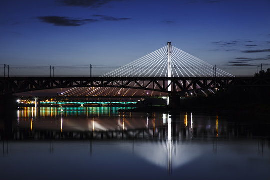 Highlighted bridge at night and reflected in the water