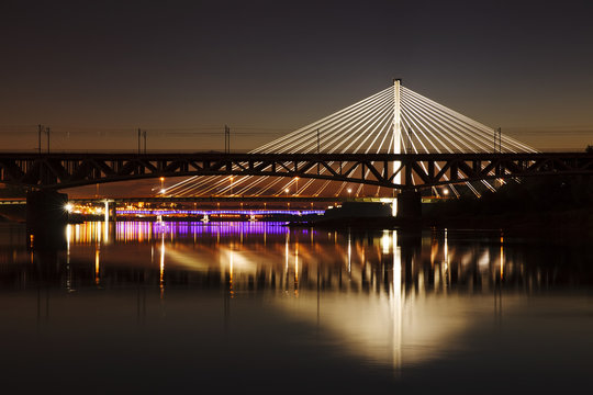 Fototapeta Backlit bridge at night and reflected in the water