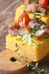 Polenta with bacon, vegetables on wooden board vertical