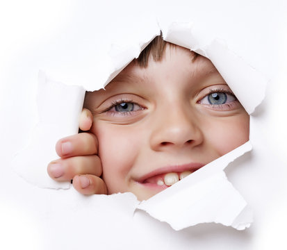 little girl looking out of a hole in a paper