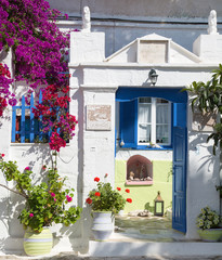 Fototapeta na wymiar Architektur auf den Kykladen: Haus mit blauer Tür u Blumen