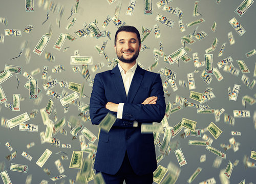 smiley businessman under dollar's rain