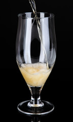 Beer pouring into glass isolated on black