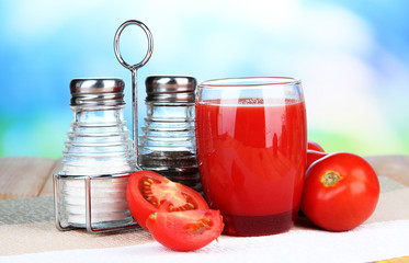 Tomato juice in glass, on wooden  table, on bright background