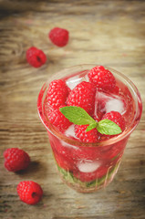 Summer juice with fresh raspberries mint and ice in a glass