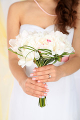 Obraz na płótnie Canvas Bride holding wedding bouquet of white peonies, close-up,