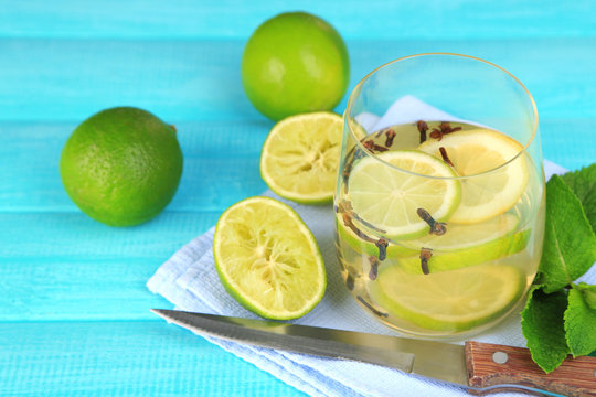 Fresh summer drink with lime and cloves in glass,