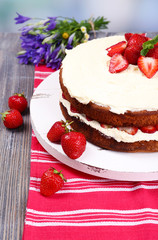 Delicious biscuit cake with strawberries on table close-up