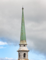 Old church spire against cloudy sky