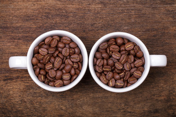cup of coffee beans on the brown wooden background