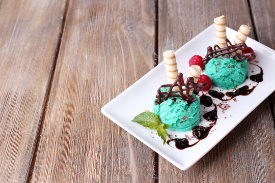Tasty ice cream with chocolate decorations and sauce plate,