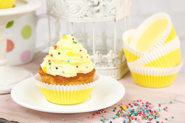 Tasty cup cake with cream on wooden table