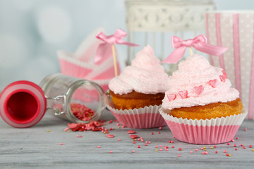 Tasty cup cakes with cream on grey wooden table