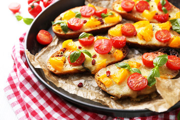 Tasty bruschetta with tomatoes in pan, on table