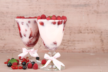 Tasty raspberry dessert with berries on pink wooden background