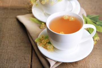 Tasty herbal tea with linden flowers on wooden table