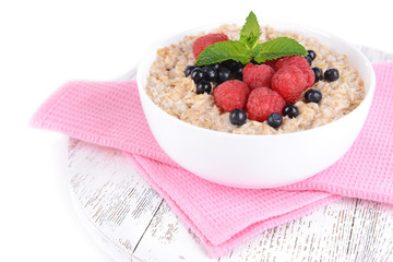 Tasty oatmeal with berries isolated on white