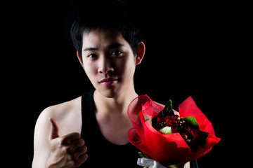 Asian boy with red bouquet in dark background