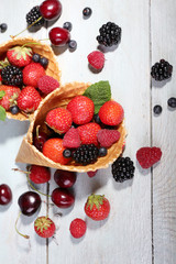 Different ripe berries in sugar cones,