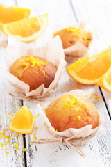 Obraz na płótnie Canvas Tasty cupcakes with orange on table close-up