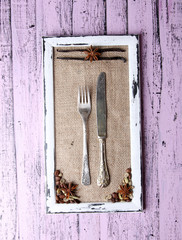 Wooden frame, spices and vintage cutlery