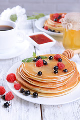 Sweet pancakes with berries on table close-up