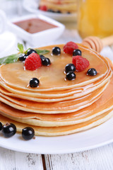Sweet pancakes with berries on table close-up