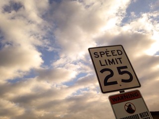 25 mph sign with clouds