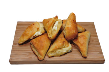Pastry buns with cheese filling on a cutting board, isolated on white background