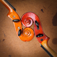 Fototapeta premium Two old violin scrolls detail over grunge background