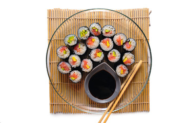 Sushi rolls on a plate with chopsticks and wasabi, top view