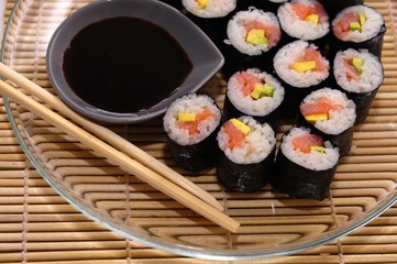 Sushi rolls on a plate with chopsticks and wasabi, top view