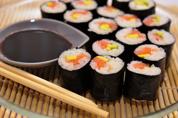 Sushi rolls on a plate with chopsticks and wasabi, top view