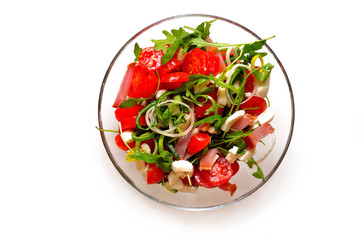 Mediterranean salad with feta cheese, tomato and rucola served in a bowl, isolated on white background