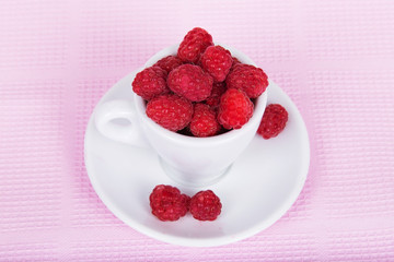 Fresh raspberries in a white cup