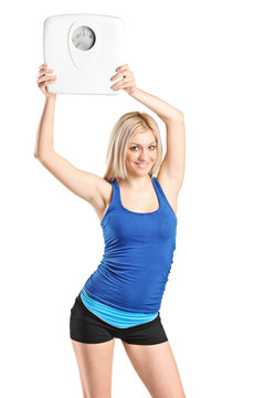 Attractive blond woman holding a weight scale