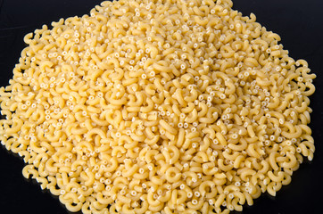 Mound of uncooked pasta elbow macaroni