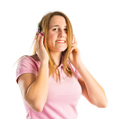 Young blonde girl listening music over white background