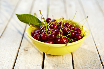 Yellow bowl full of fresh cherries