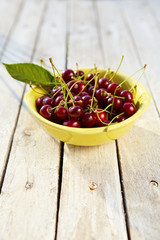 Yellow bowl full of fresh cherries