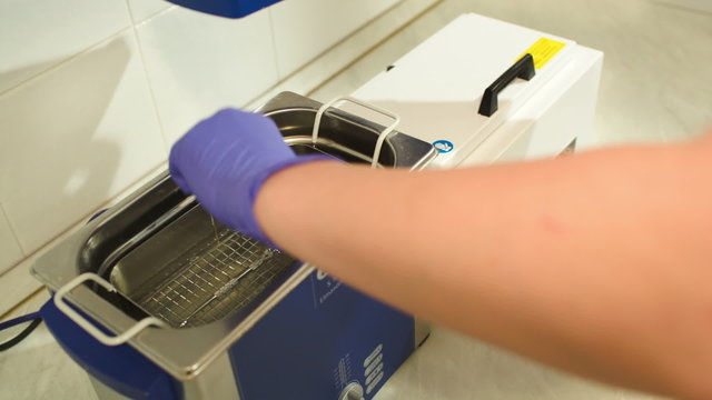 Beautician putting reusable instrument into sterilizer