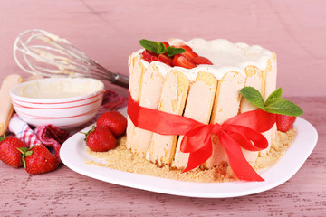 Tasty cake Charlotte with fresh strawberries on wooden table