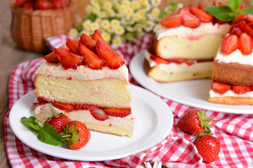 Delicious biscuit cake with strawberries on table close-up